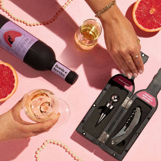 pink background flat lay with wine bottles and glasses